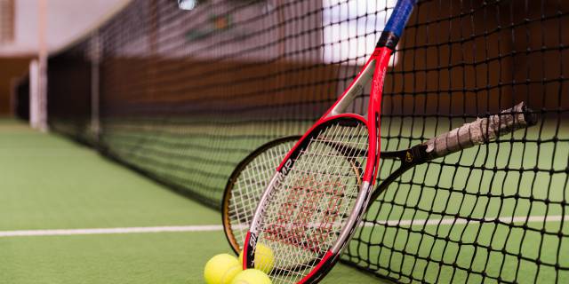 Tennisschläger an Tennisnetz gelehnt