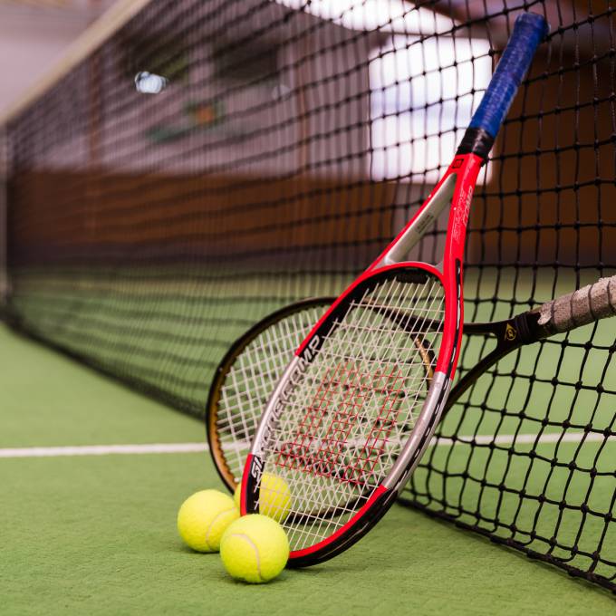 Tennisschläger an Tennisnetz gelehnt
