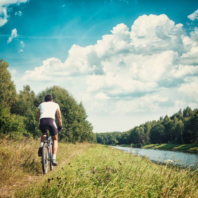 Fahrradfahrer fährt entlang des Flusses