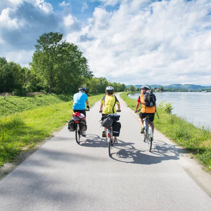 Fahrradfahrer radeln entlang eines Flusses